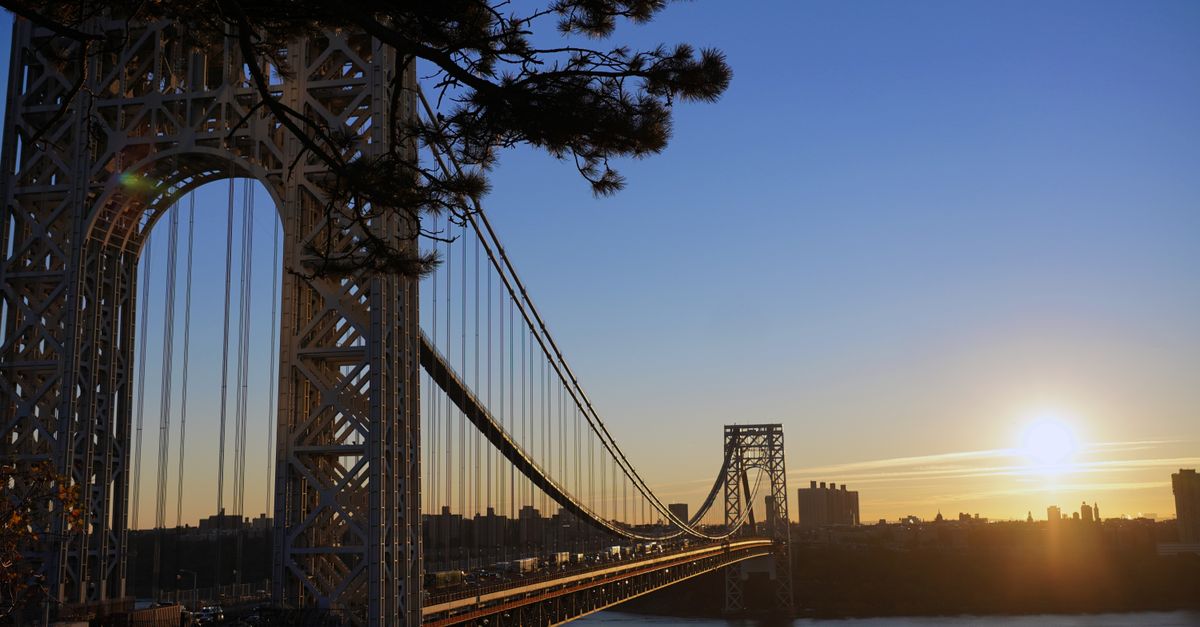 Stunning view of George Washington Bridge against a sunrise backdrop over the Hudson River, connecting New Jersey and New York City.